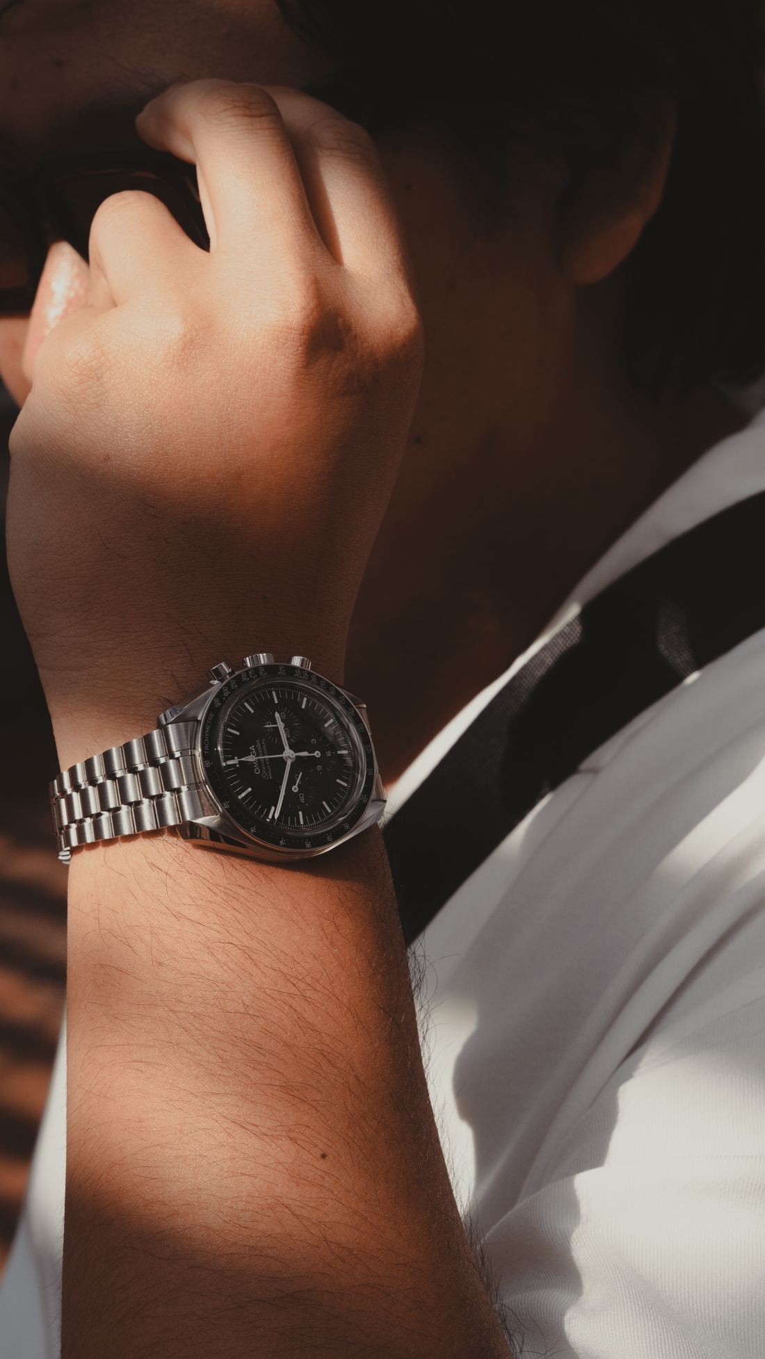 A steel dive watch on the wrist, cuff pushed back