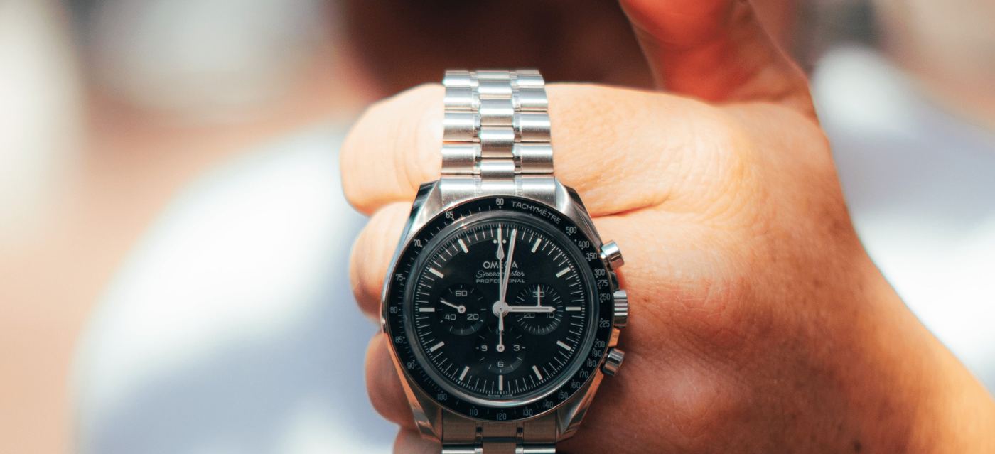 A steel chronograph held up in daylight
